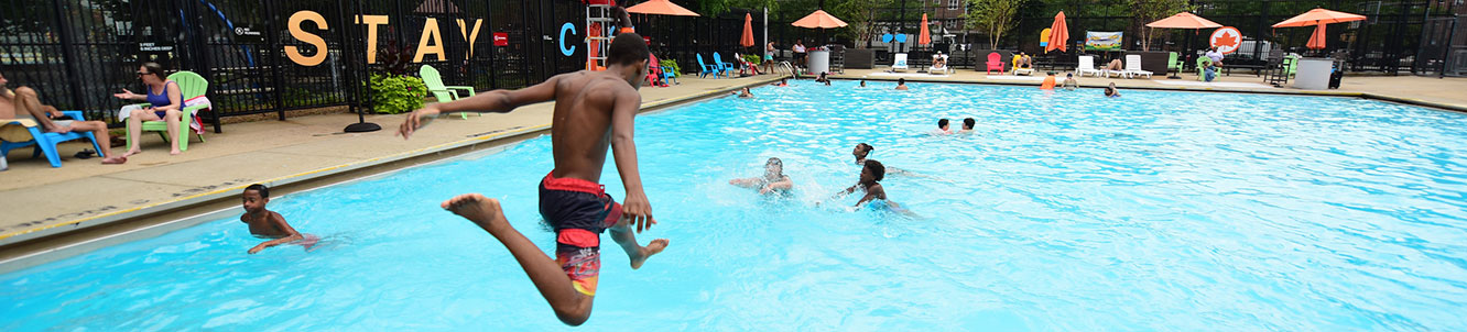 A child jumping into a busy city pool.