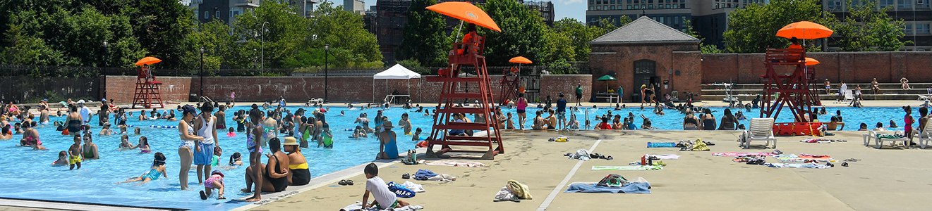 A massive and popular outdoor pool with a red brick poolhouse.