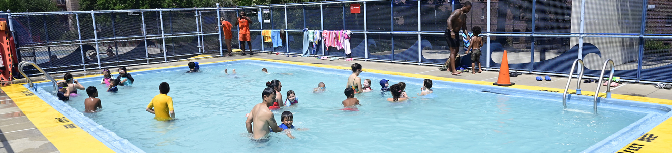 A fun and crowded shallow children's pool in a busy park.