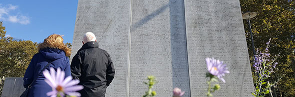 a man and woman look at a U.S. Navy war memorial in The Battery