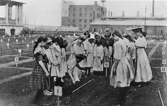 A class, mostly of girls, carefully observes its teacher during a lesson, circa 1905. Source: Parks Department 1905 Annual Report.