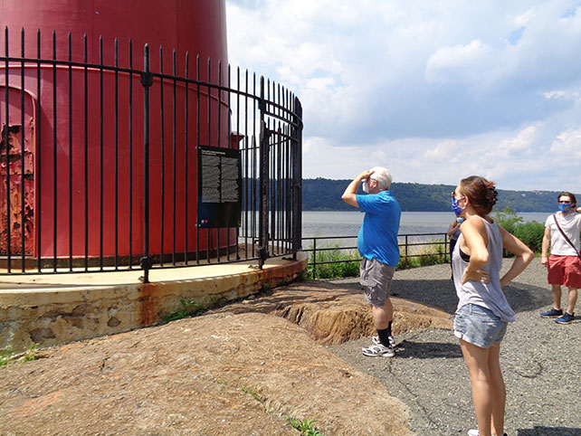 Visitors read historical sign at Little Red Lighthouse