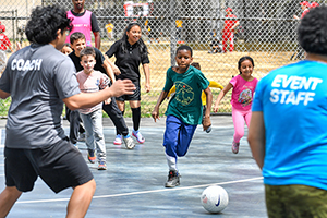 A group of children play soccer.