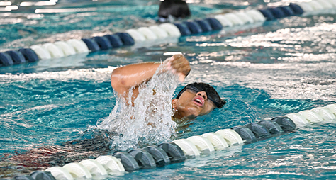 A teenager in the            middle of a strenuous swim stroke.