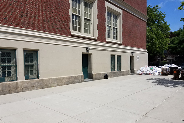 A concrete surface in front of a brick building