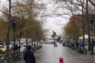 Mother and child walking in Dag Hammerskjold Plaza on rainy afternoon. 