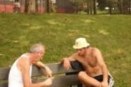 Father and son playing friendly game of chess on warm August day in Astoria Park. 